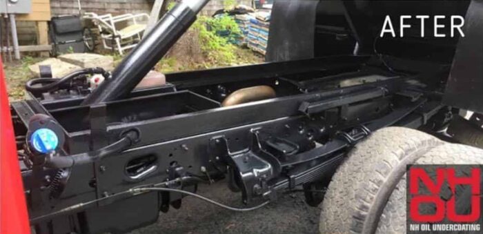 The same pickup truck frame after treatment, evenly coated in black NHOU oil undercoating